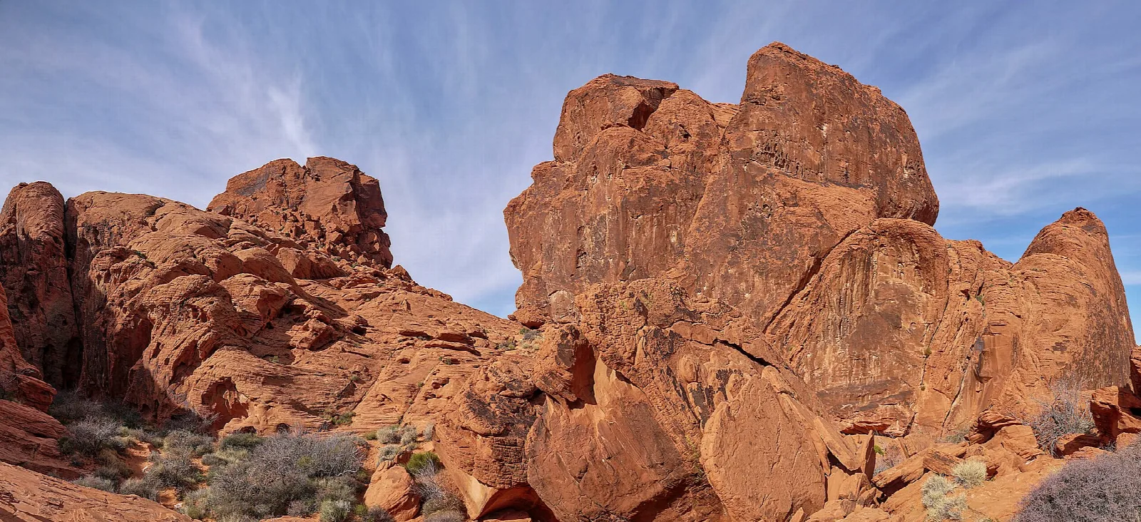 Large red sandstone boulders against a sky with thin clouds