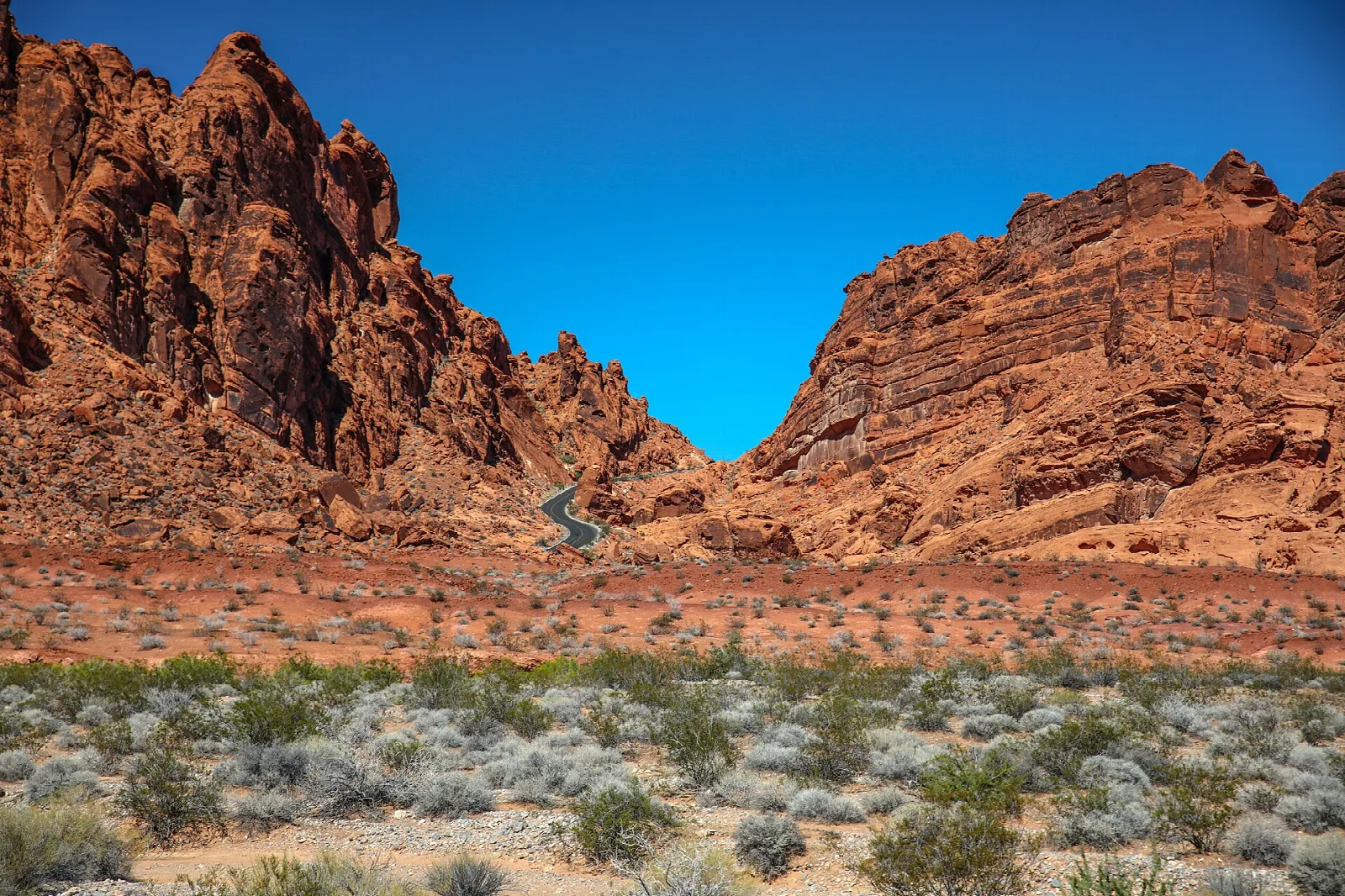 Red sandstone cliffs on both sides of a desert valley