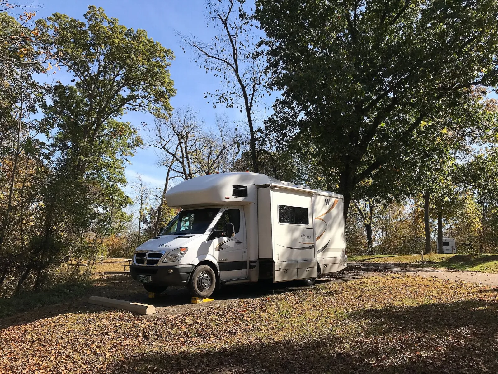 Camper van parked at a campsite under trees