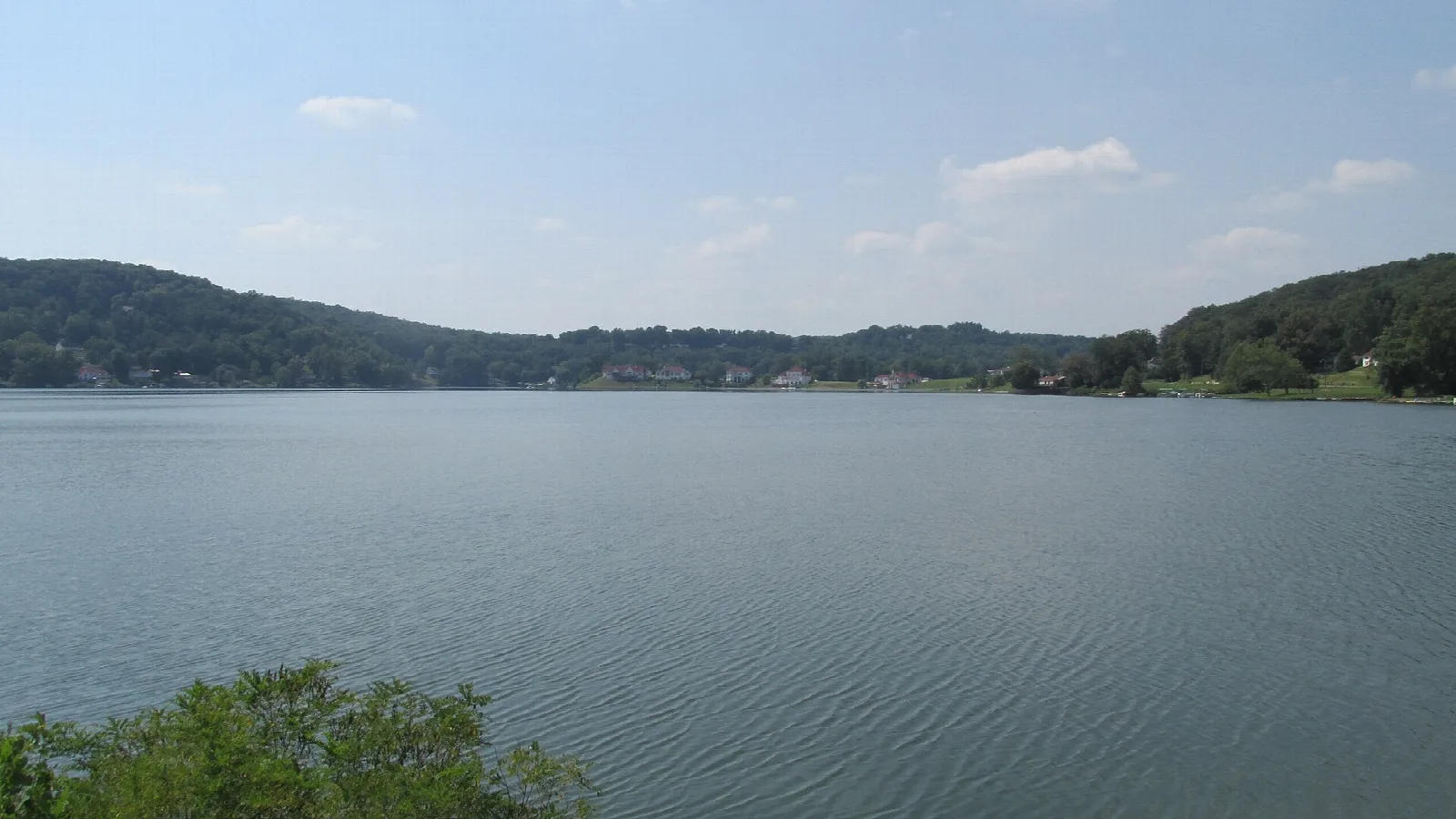 Calm lake with tree-covered hills on the far shore