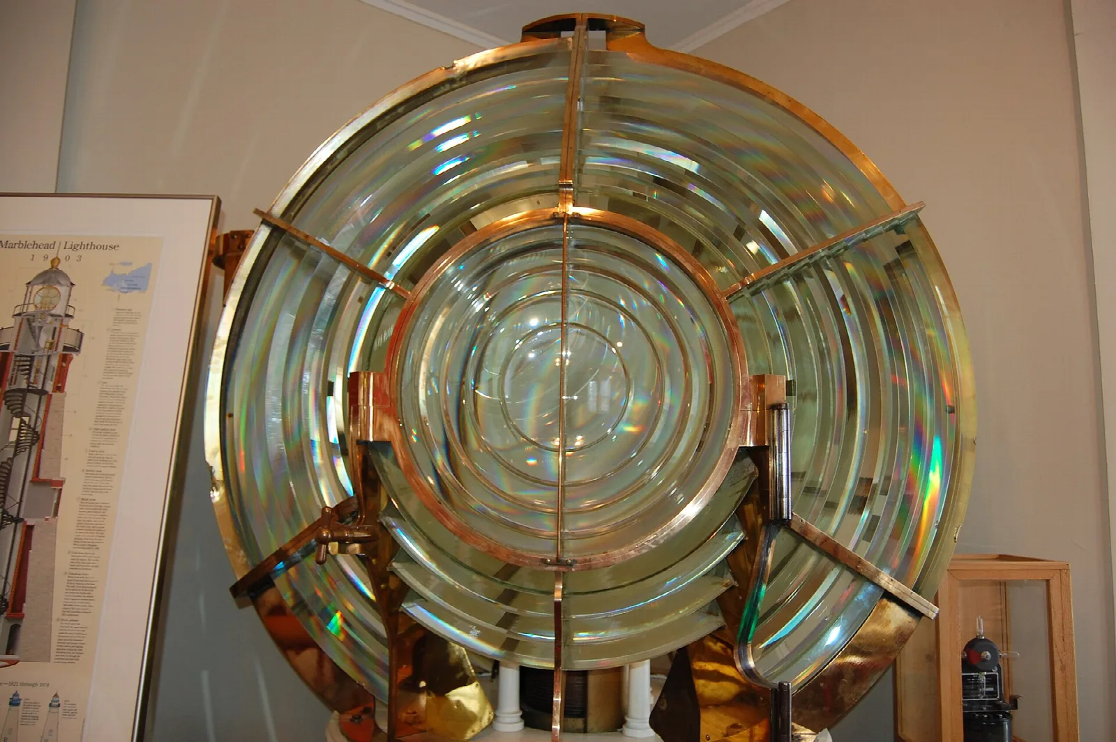 Brass Fresnel lens on display in a museum room