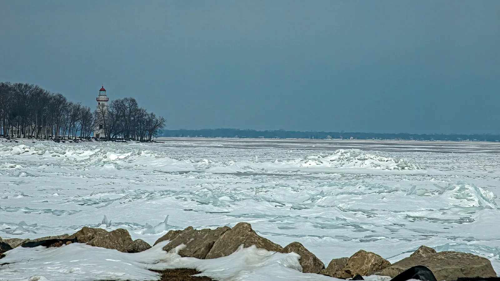 Lighthouse in the distance across frozen Lake Erie