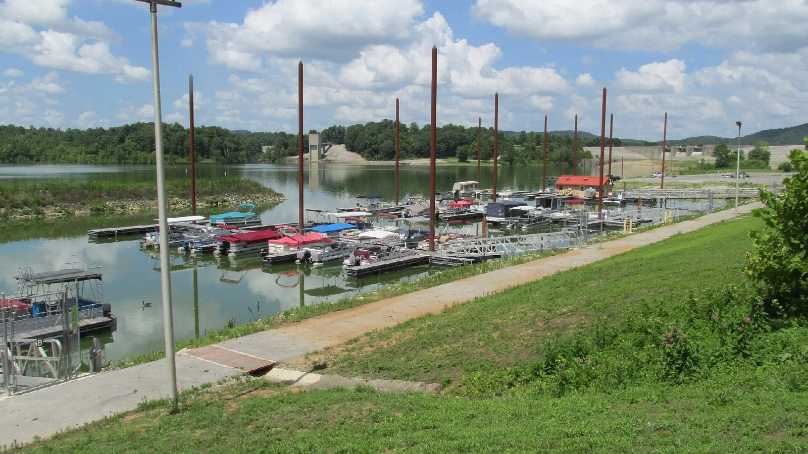 Boat marina with moored boats along a lakeside walkway