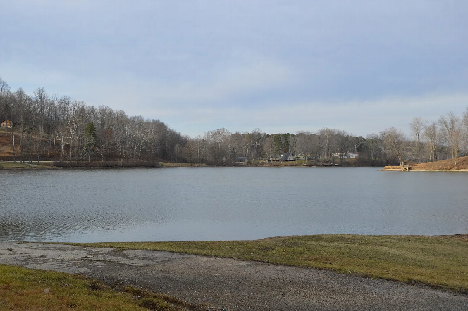 Lake with a boat ramp and bare trees on the far shore