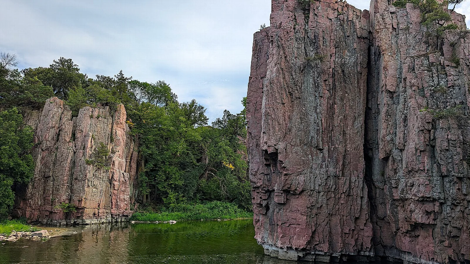 Tall quartzite cliffs on both sides of a green creek
