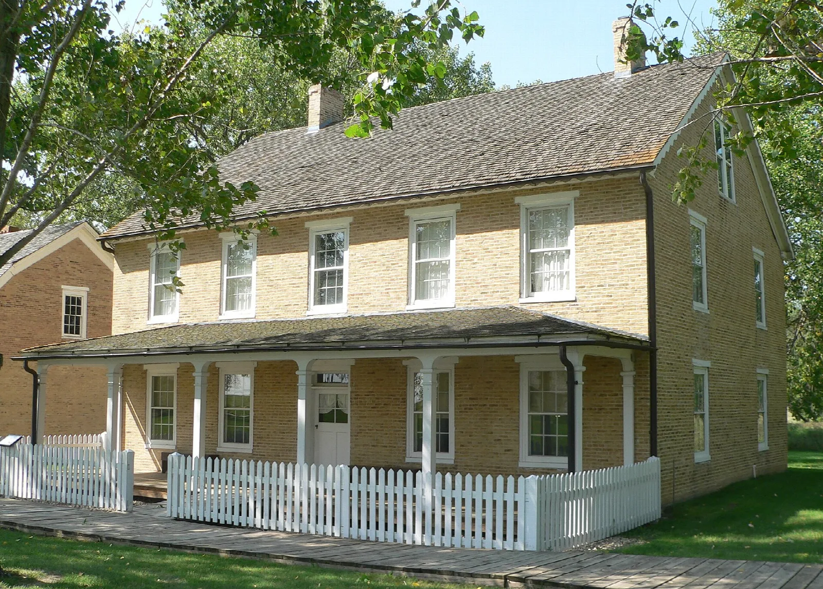 Two-story brick commanding officer's quarters with a porch and white railing