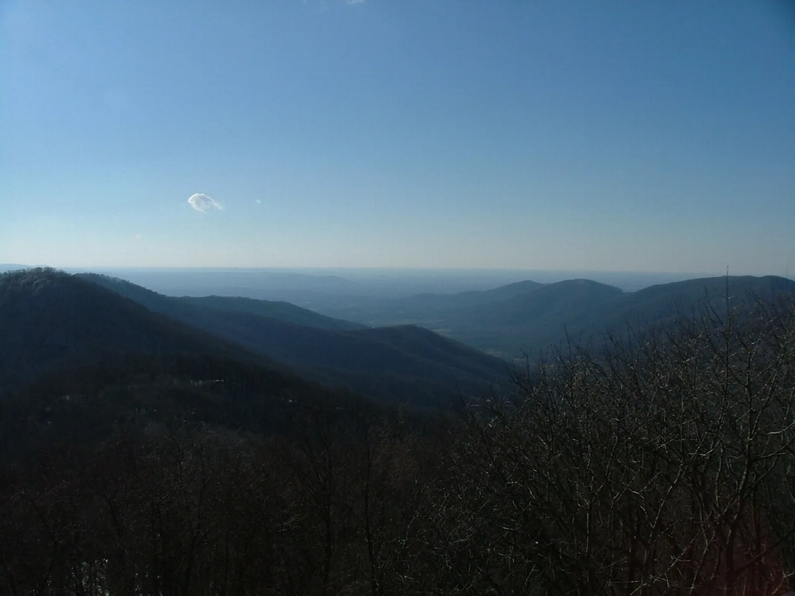 Mountain ridge silhouettes under a blue sky