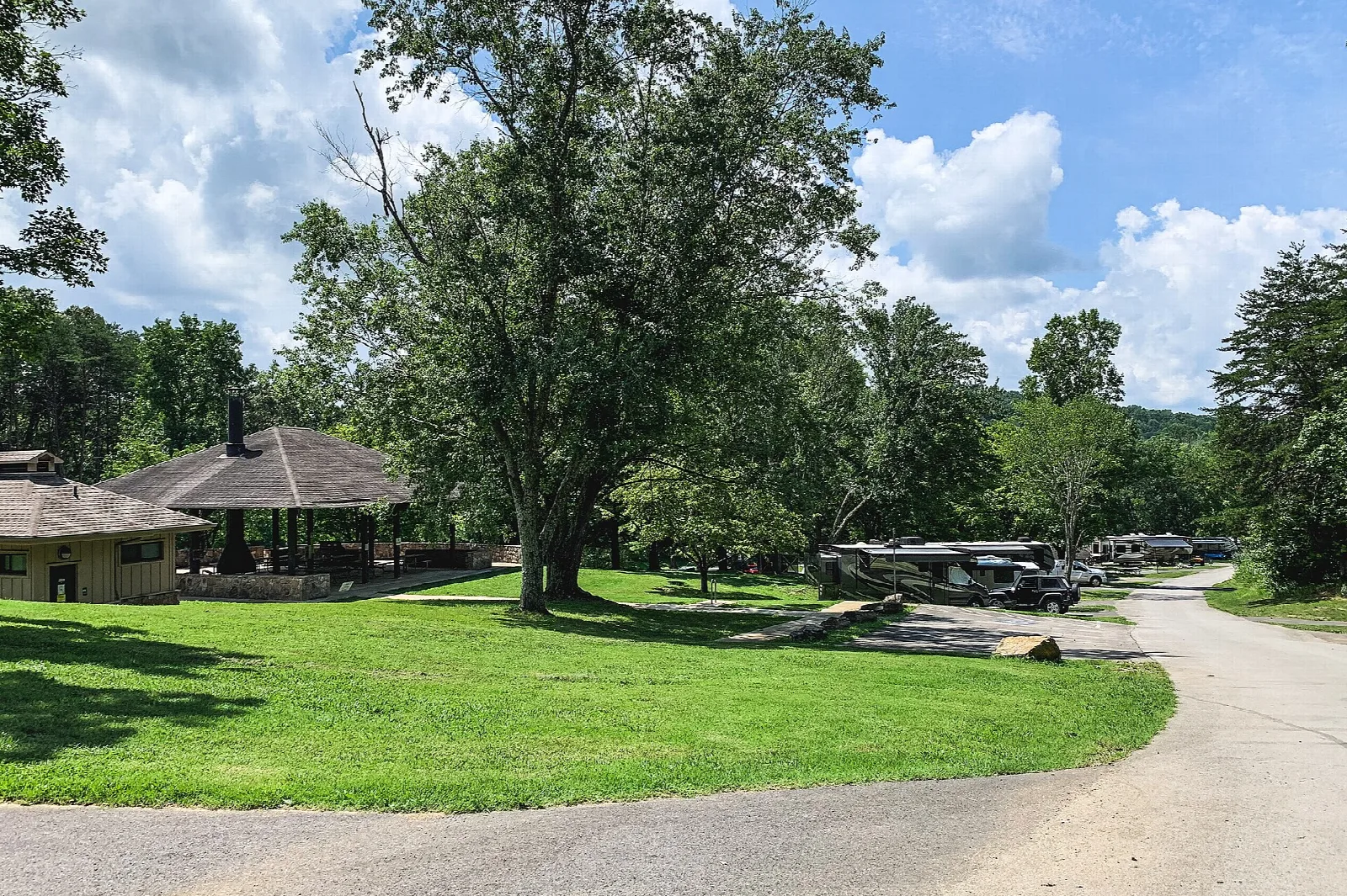 Grassy campground area with shelters and trees