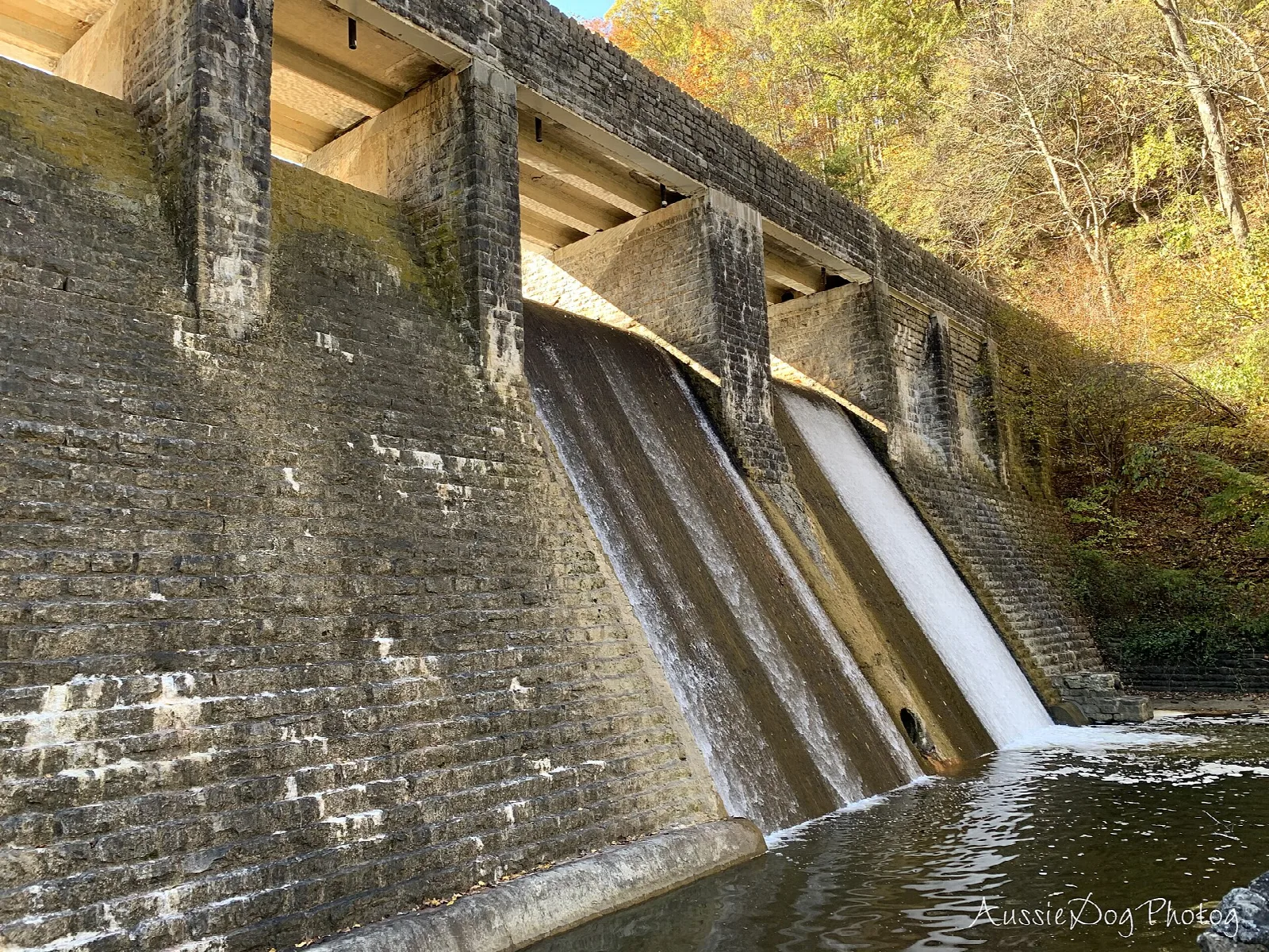 Water spilling down the face of a stone dam