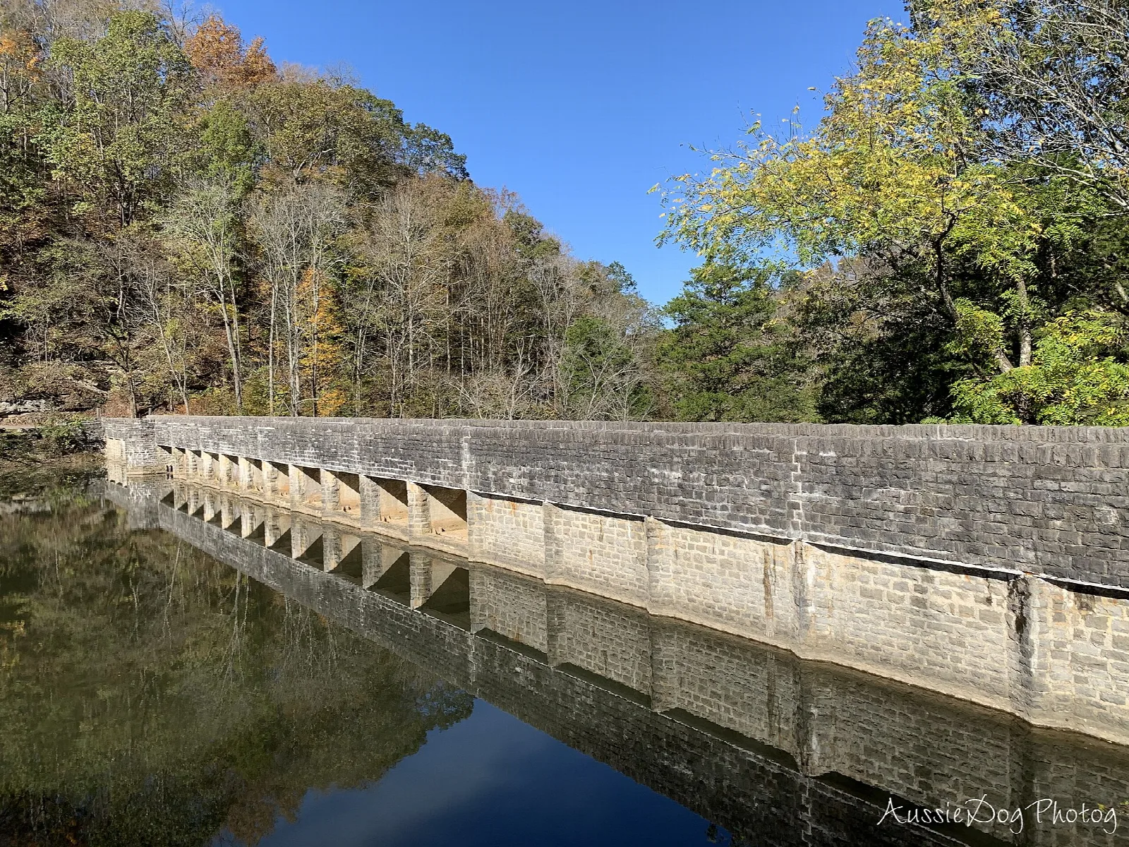 Stone dam wall running across the lake