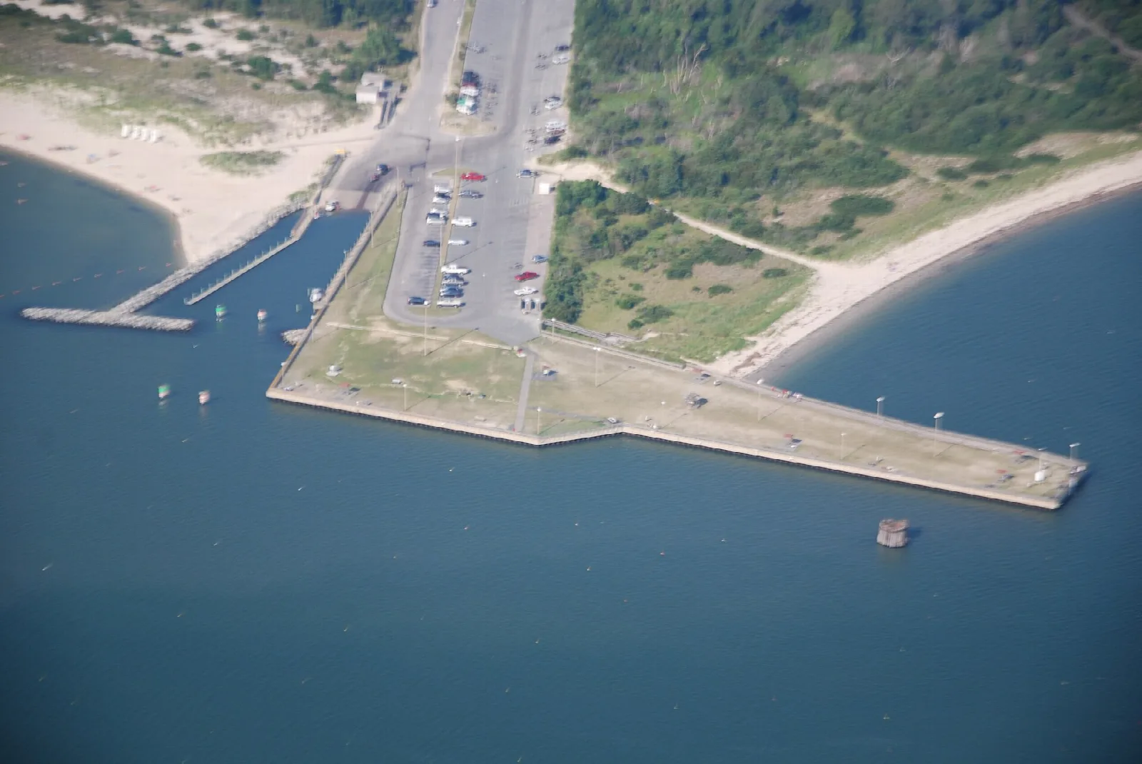 Aerial view of a fishing pier and parking area between two beaches