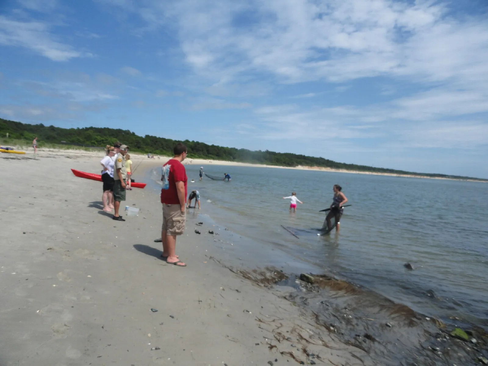 Sandy beach with people at the edge of the bay