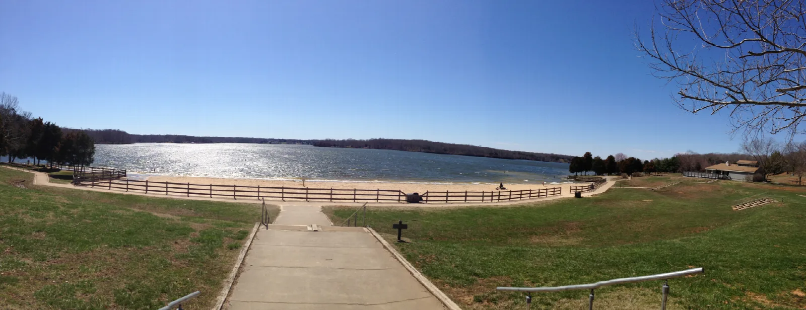 Wide view of the lake and swimming beach with a paved path