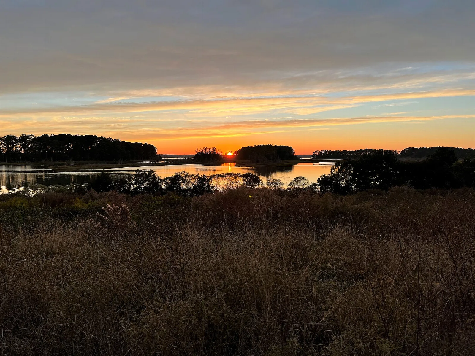 Sunset over marsh and low islands with orange sky