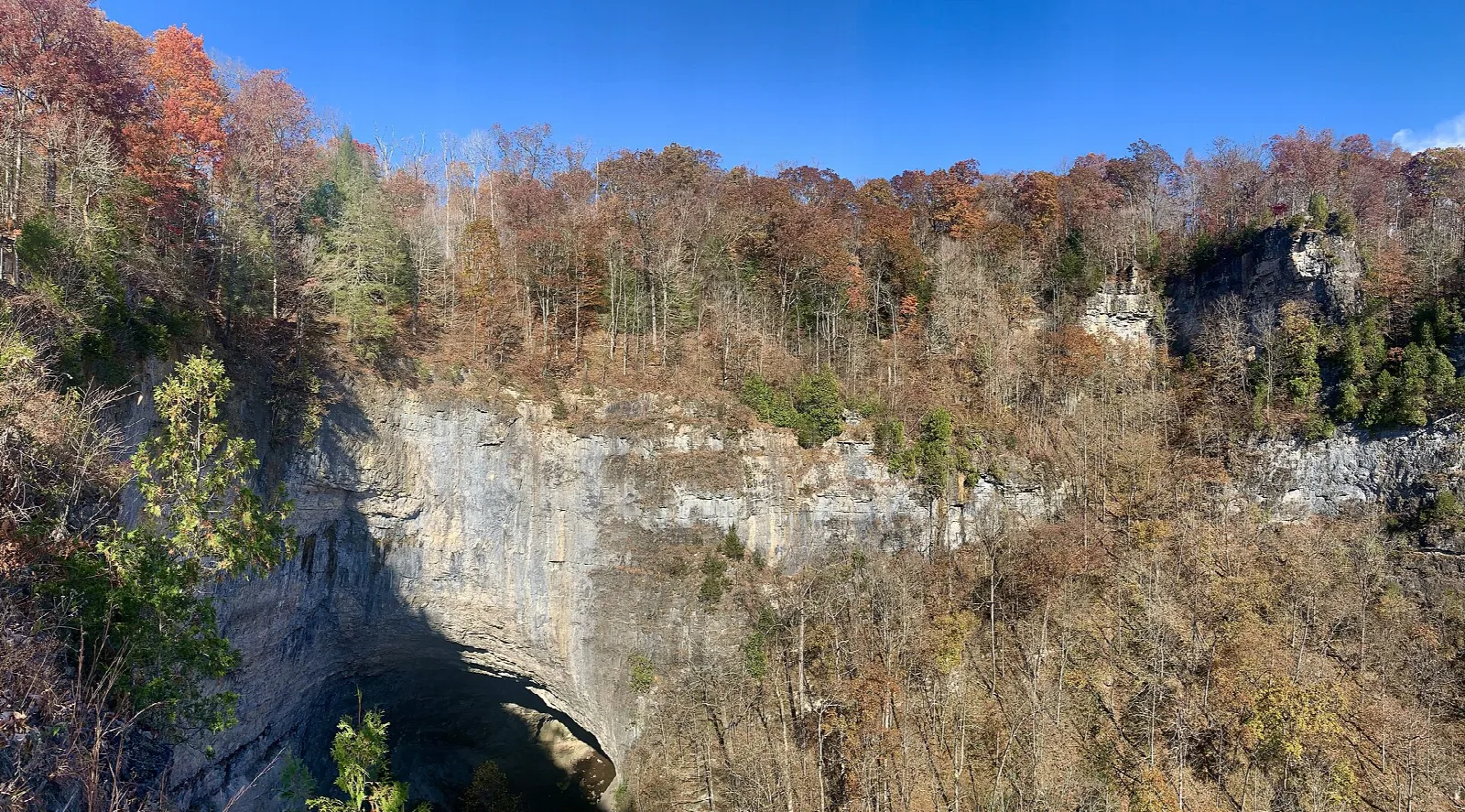 Limestone cliffs and autumn trees around the tunnel mouth