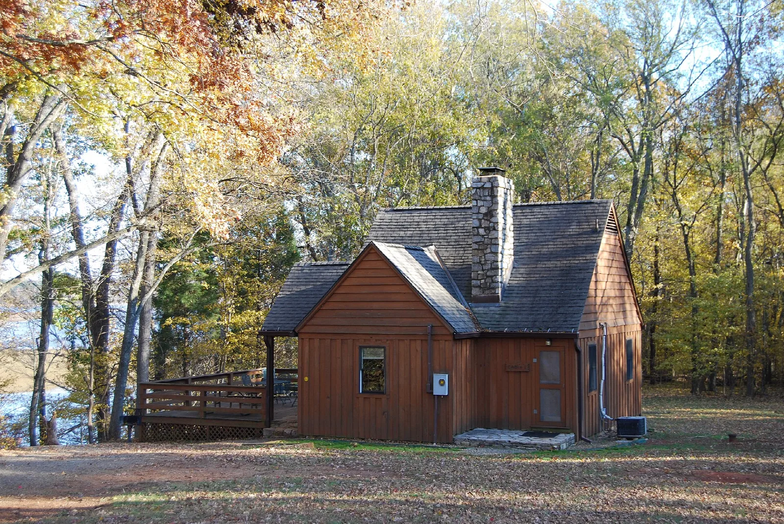 Brown wood cabin among fall trees near the water