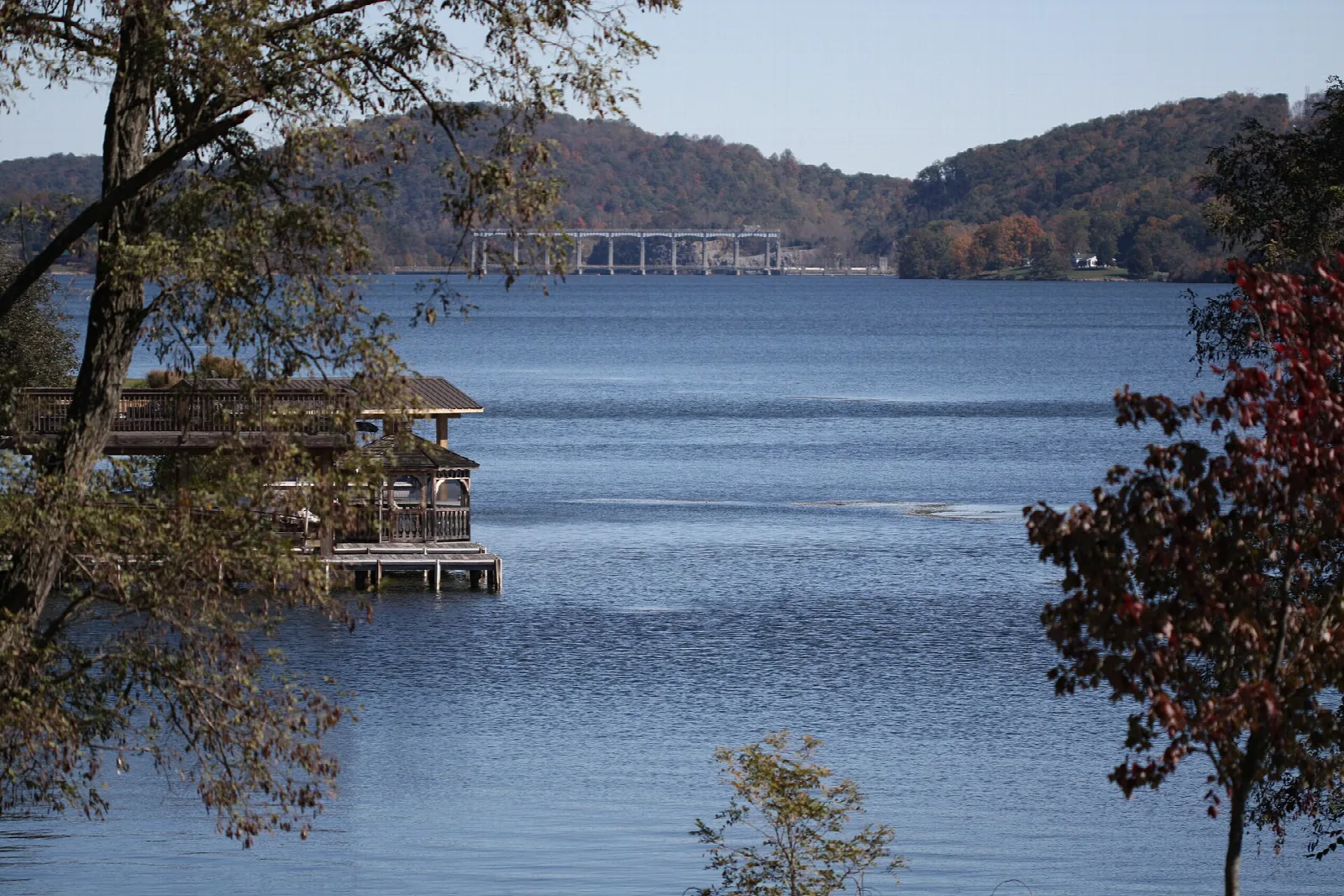 Blue lake with a boat dock and wooded hills
