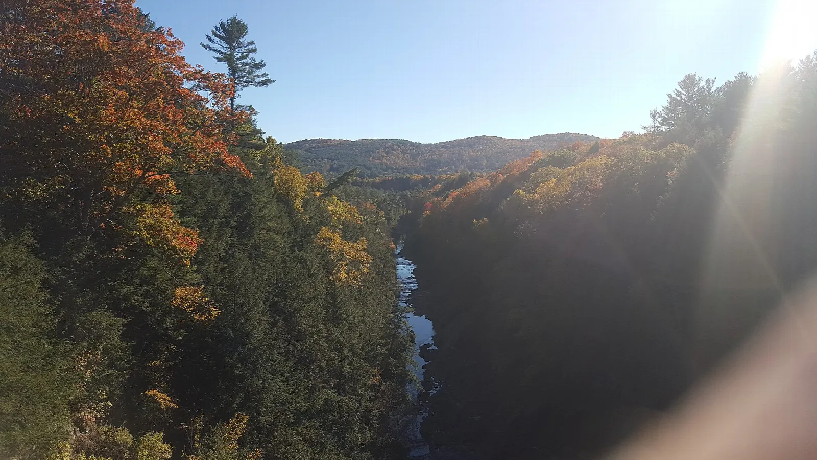 Autumn-colored gorge with a river and distant hills
