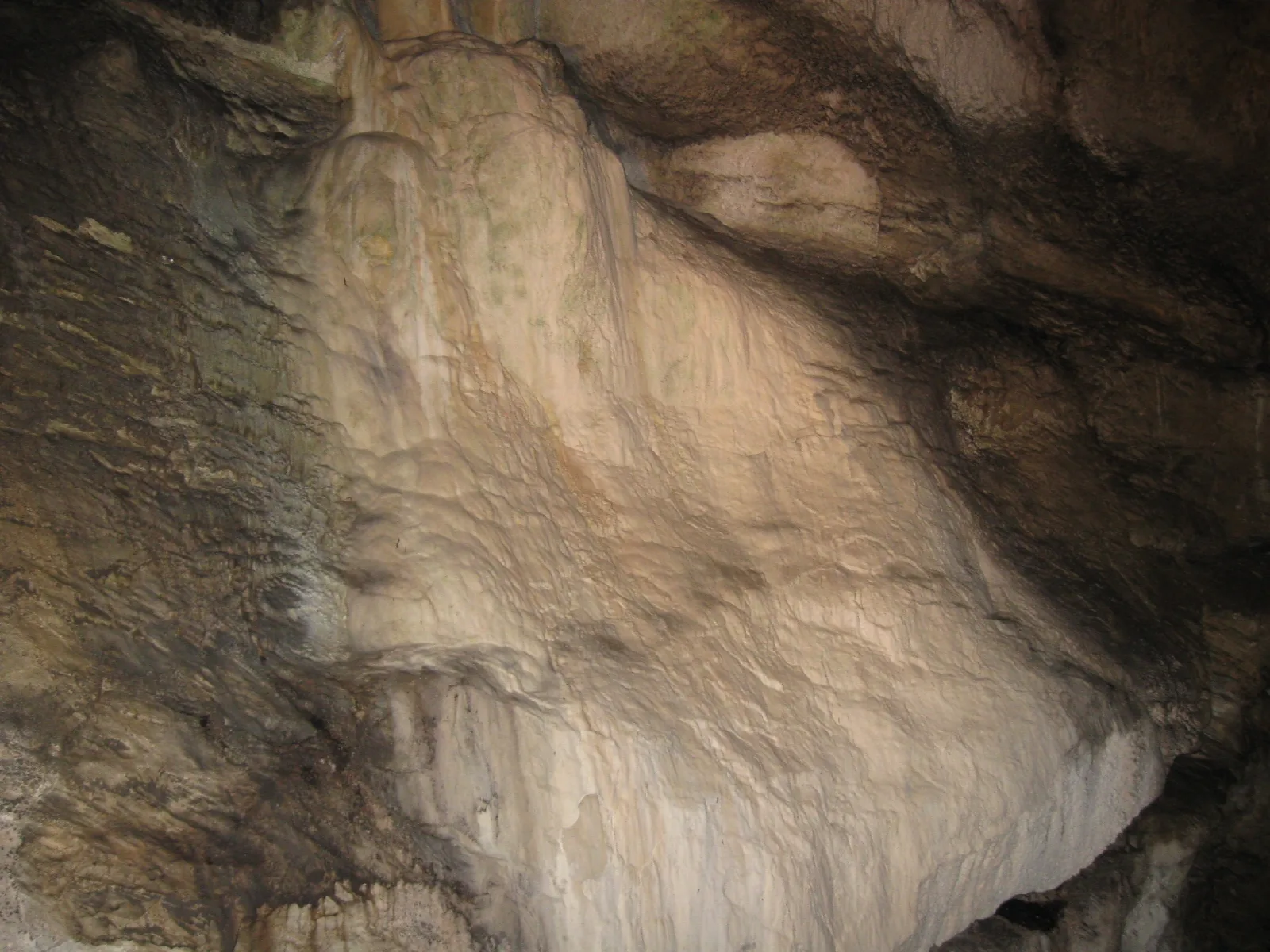 Smooth pale flowstone formation on a cave wall