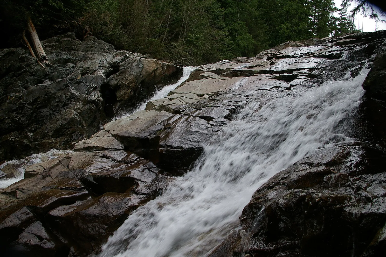 Water sliding down a dark rock slab