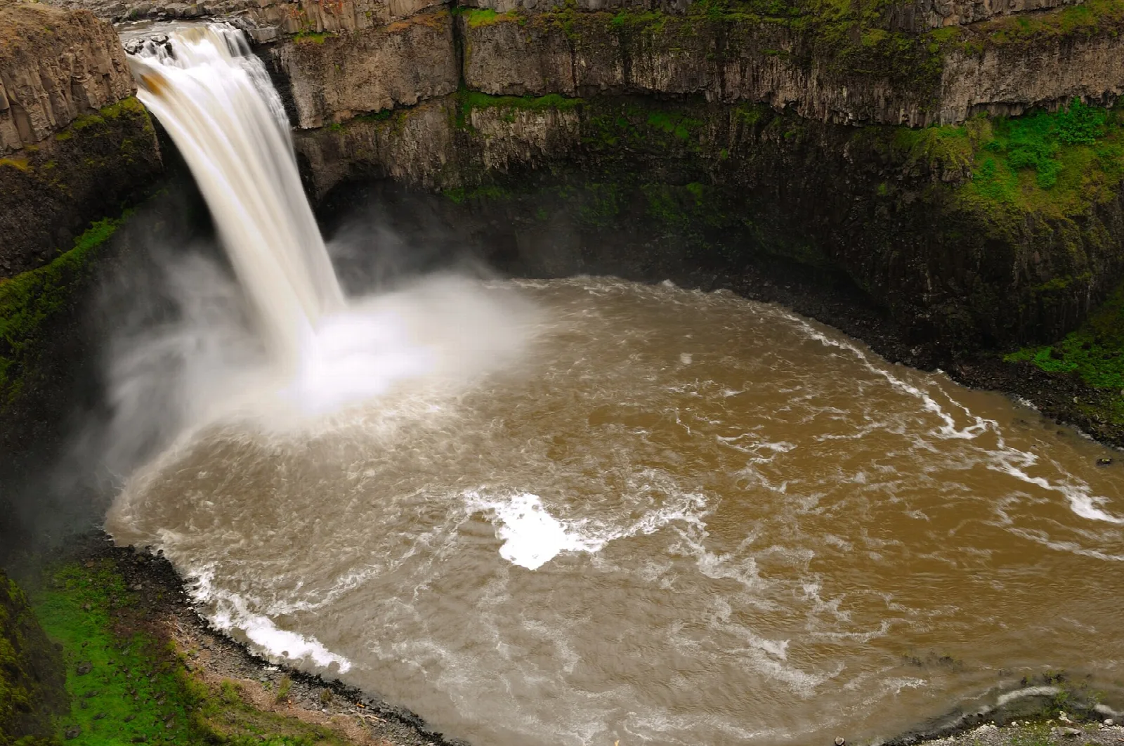 Tall falls plunging into a brown pool