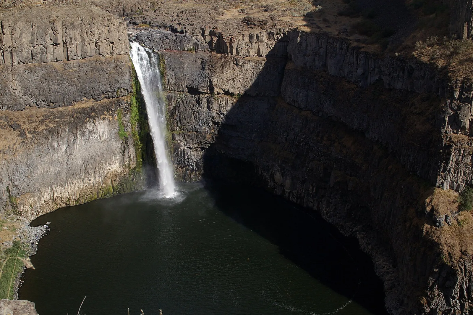 Slim waterfall down a dark canyon wall