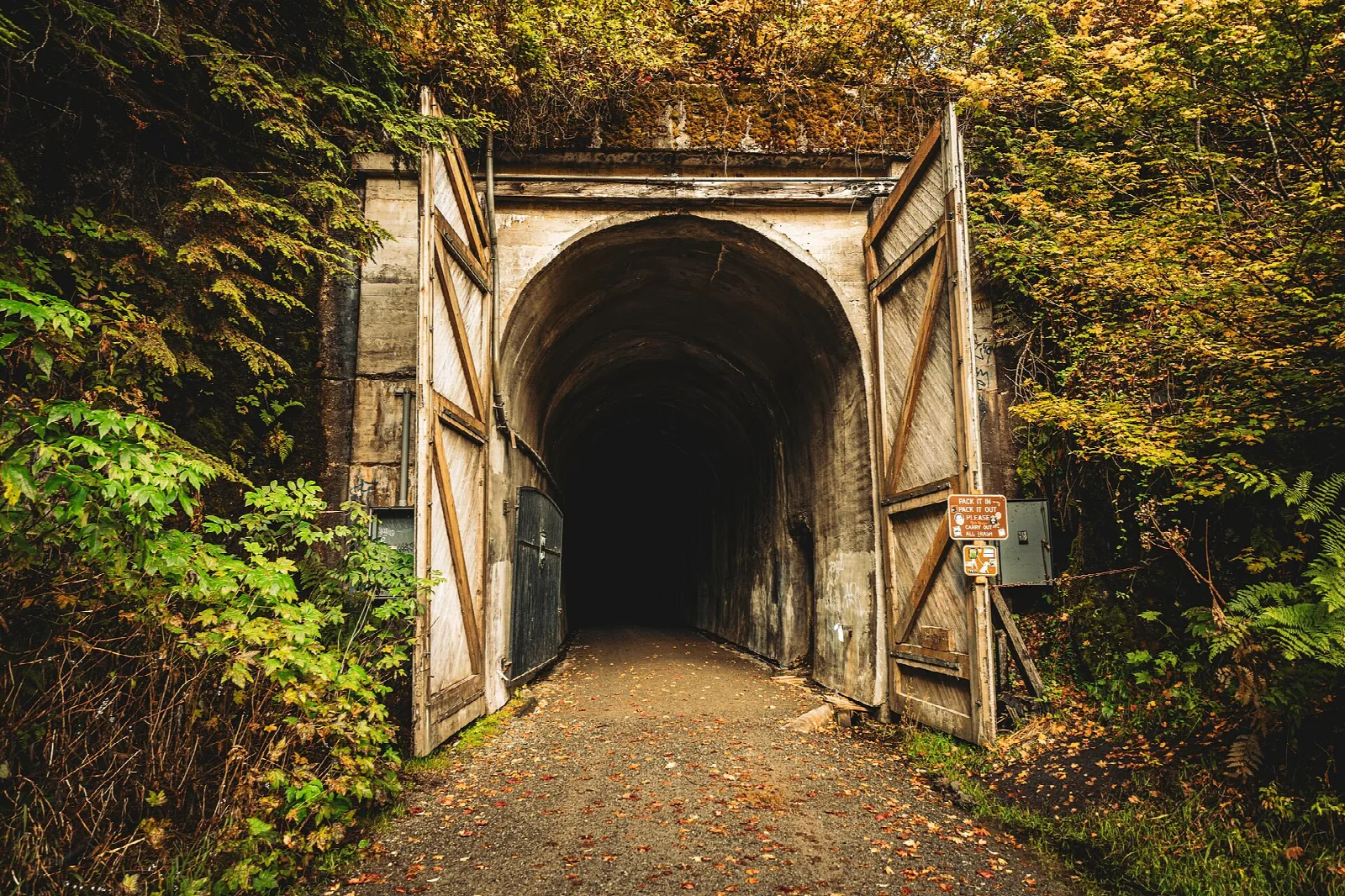 Open tunnel portal with doors in autumn foliage
