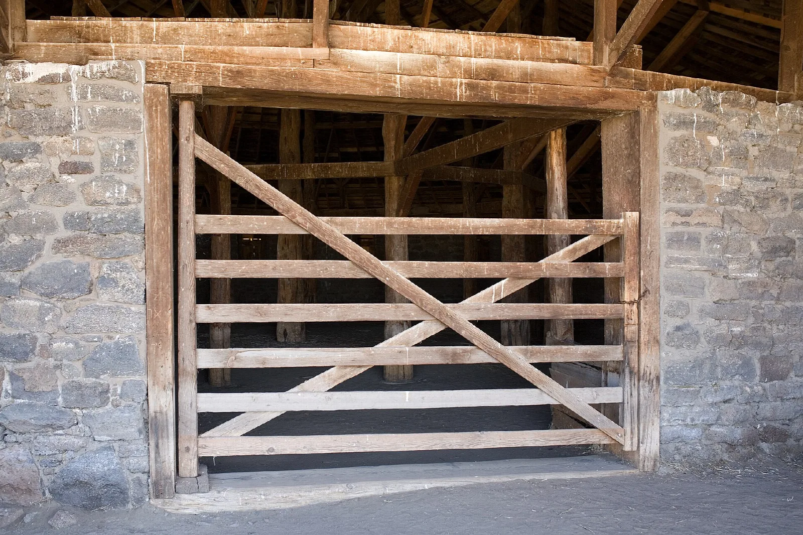 Heavy wooden gate set in a stone wall