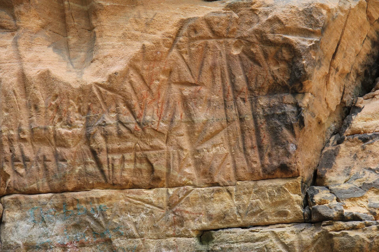 Sandstone wall covered with carved marks
