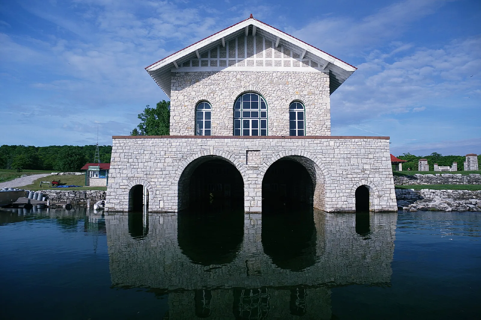 Stone boathouse with two arched openings standing at the water's edge