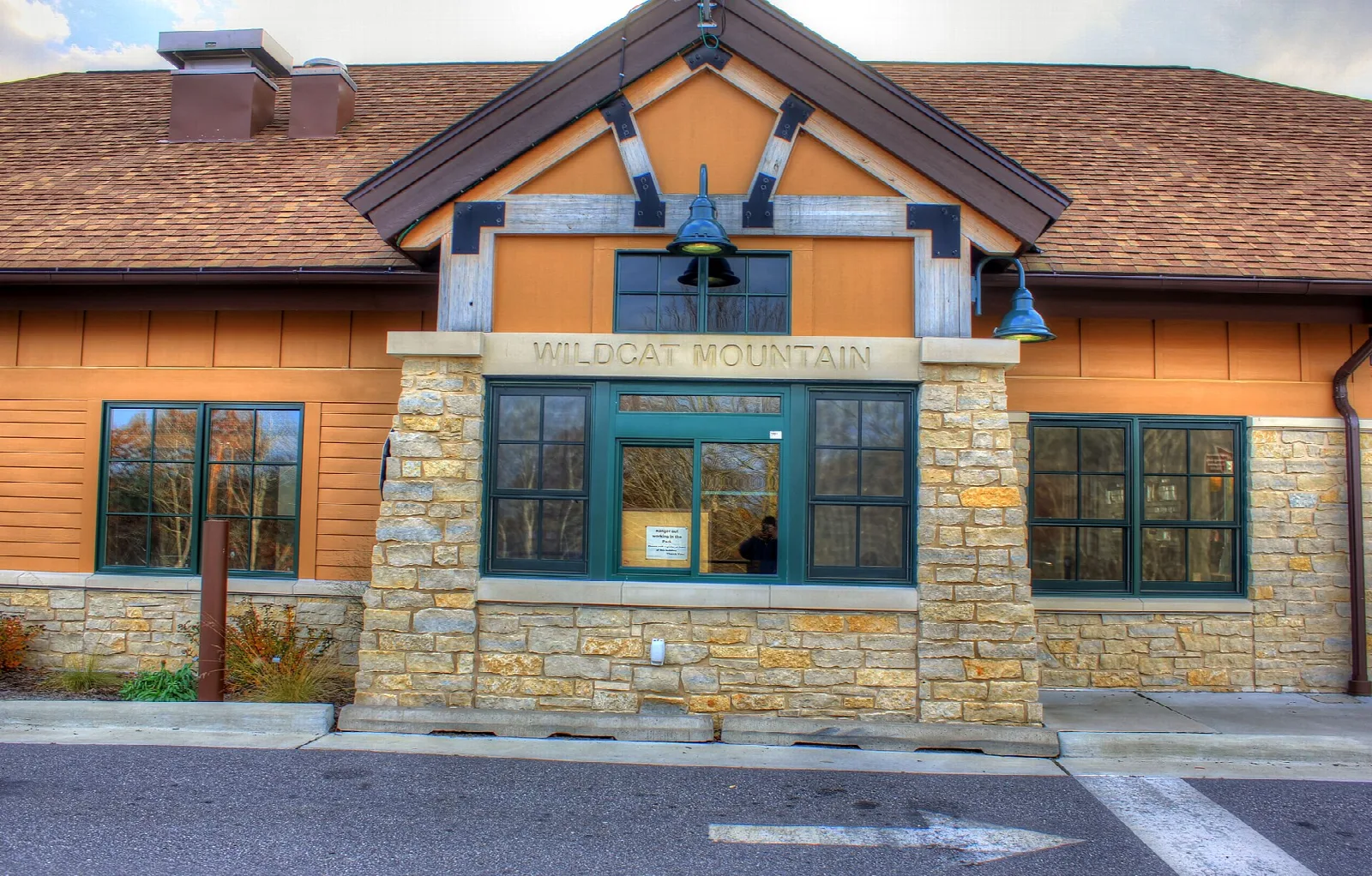 Park building with stone columns and an orange wood front