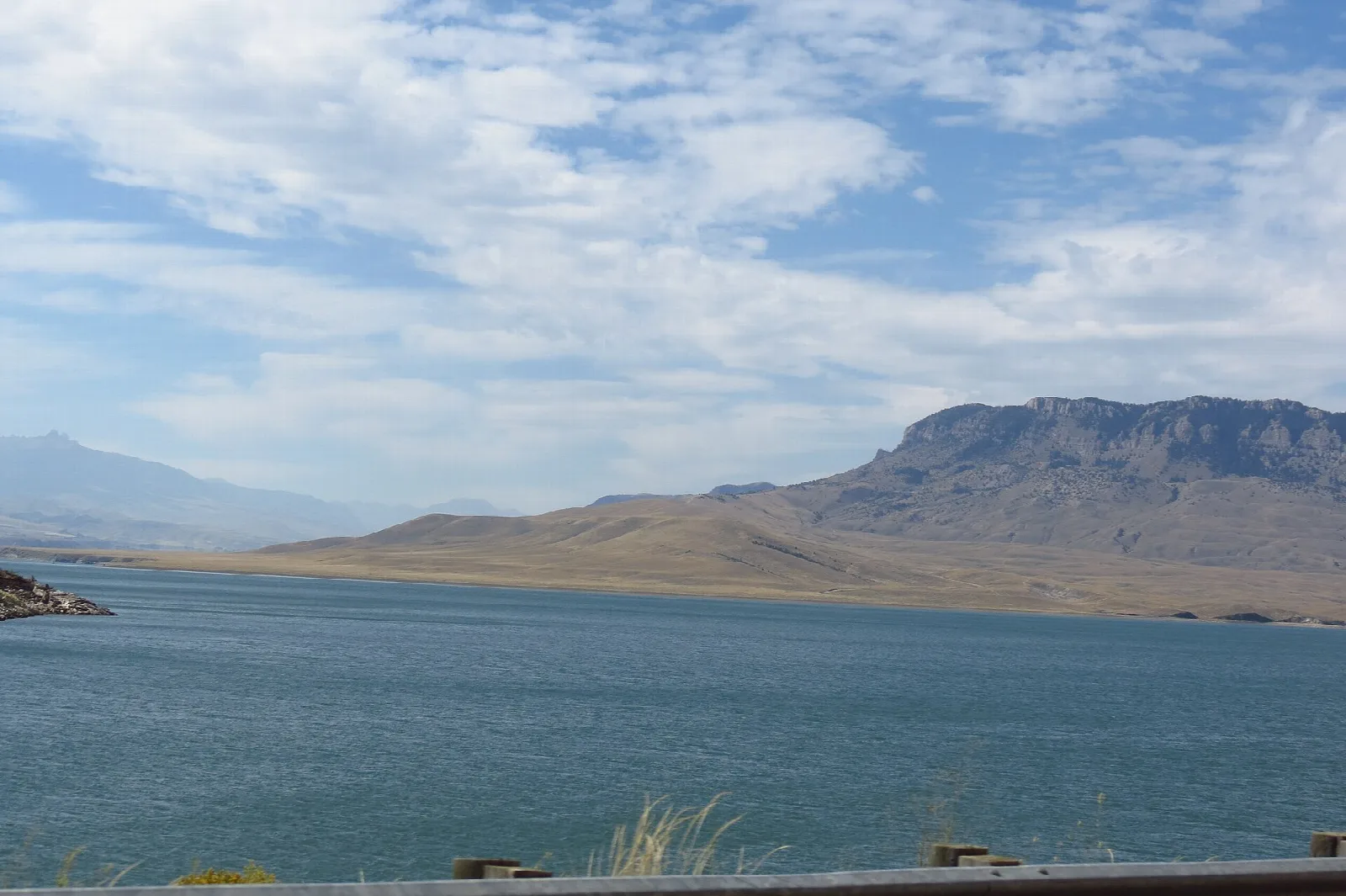 Blue reservoir with a flat-topped mountain and big clouds