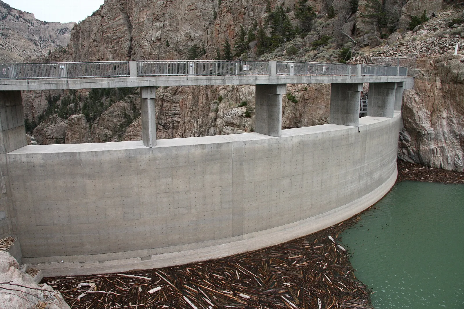 Curved concrete dam wall against a rock canyon