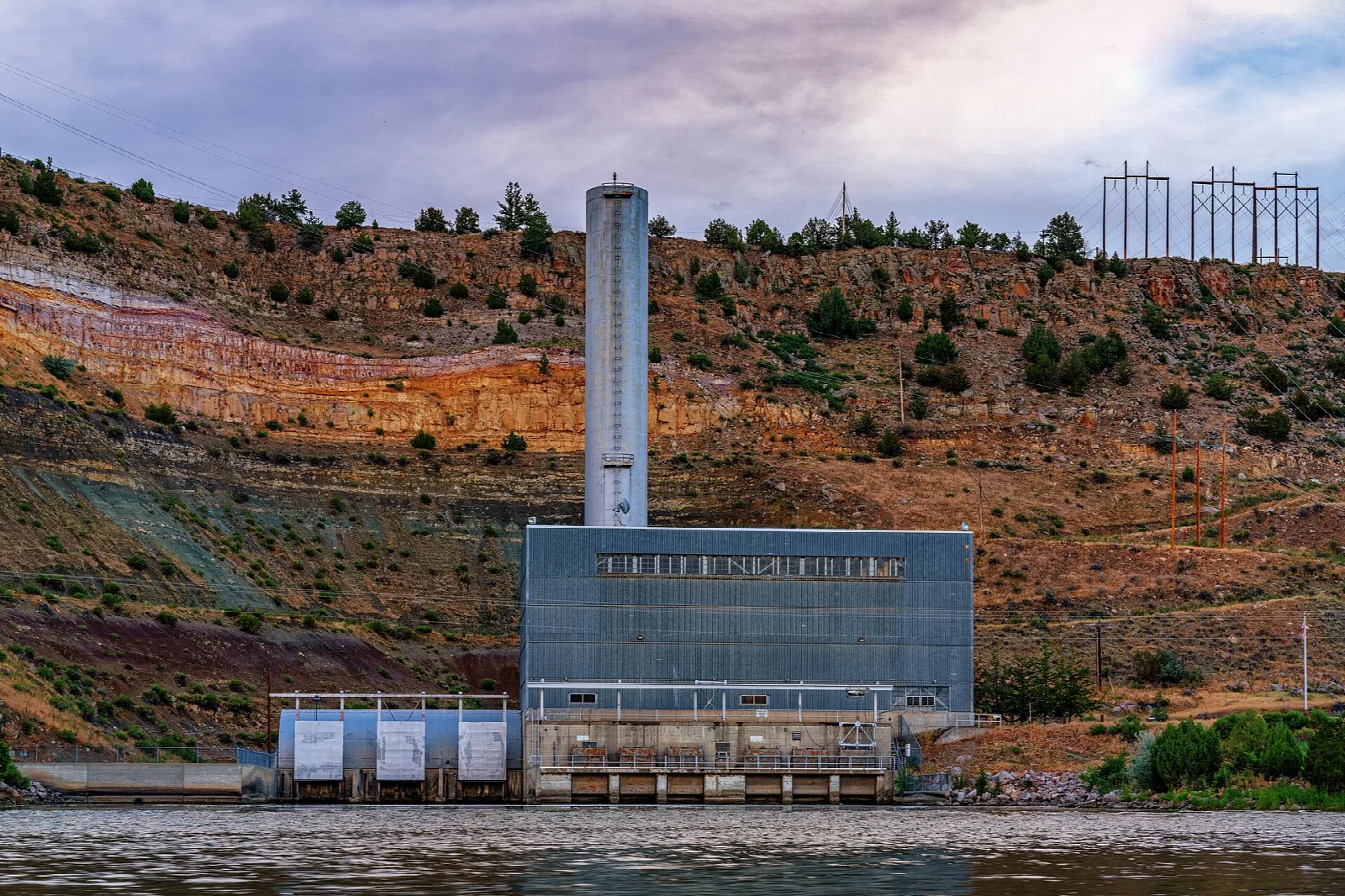 Power plant beside the reservoir under a colorful hillside