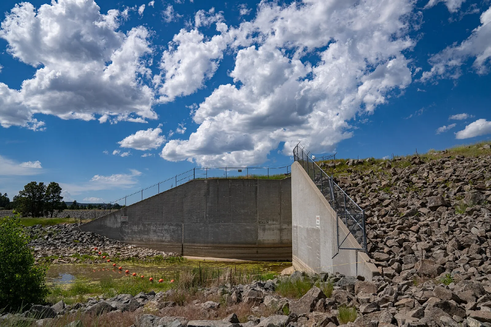 Concrete spillway structure beside a rocky bank