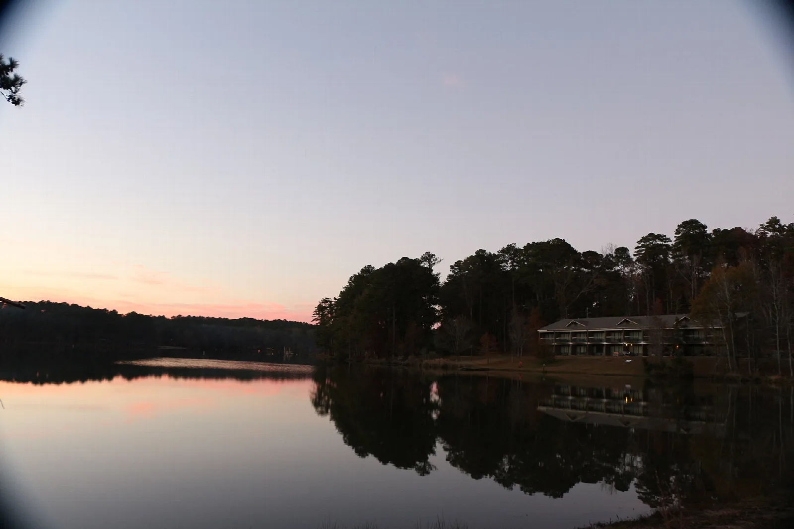 Lake at dusk with a long building on the far shore