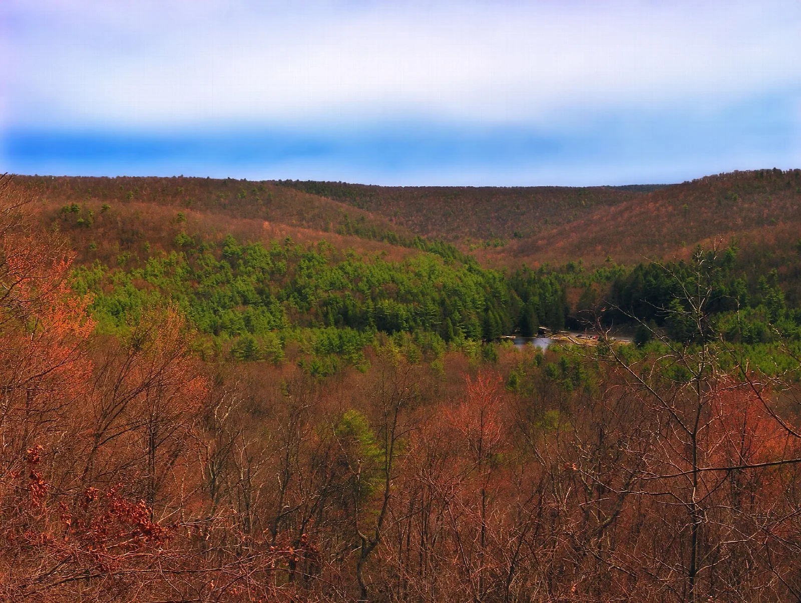 Rust-colored hills seen from a clouded overlook