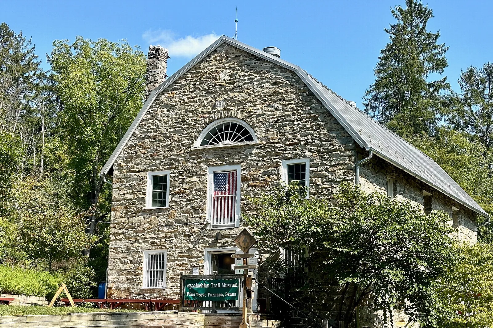 Old stone mill building behind trees