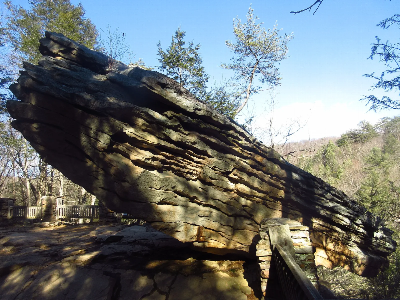 Large layered rock slab tilting out from a hillside