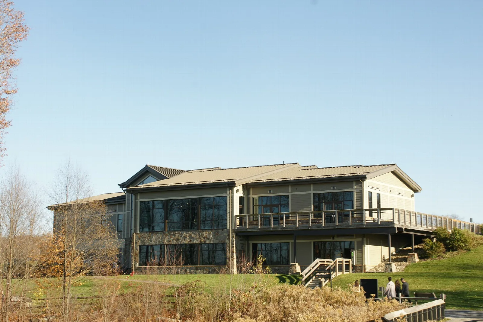 Modern visitor center building with a deck beside a lawn