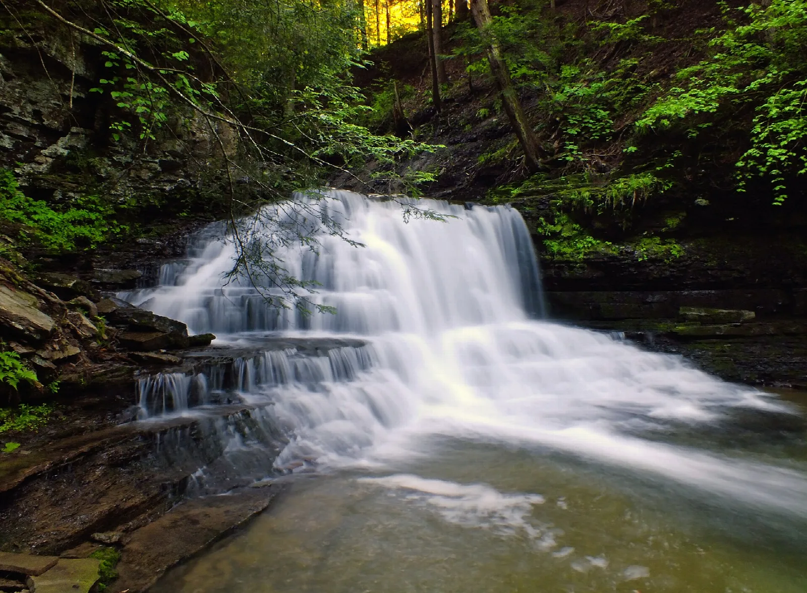 Waterfall dropping over a rock lip into a pool