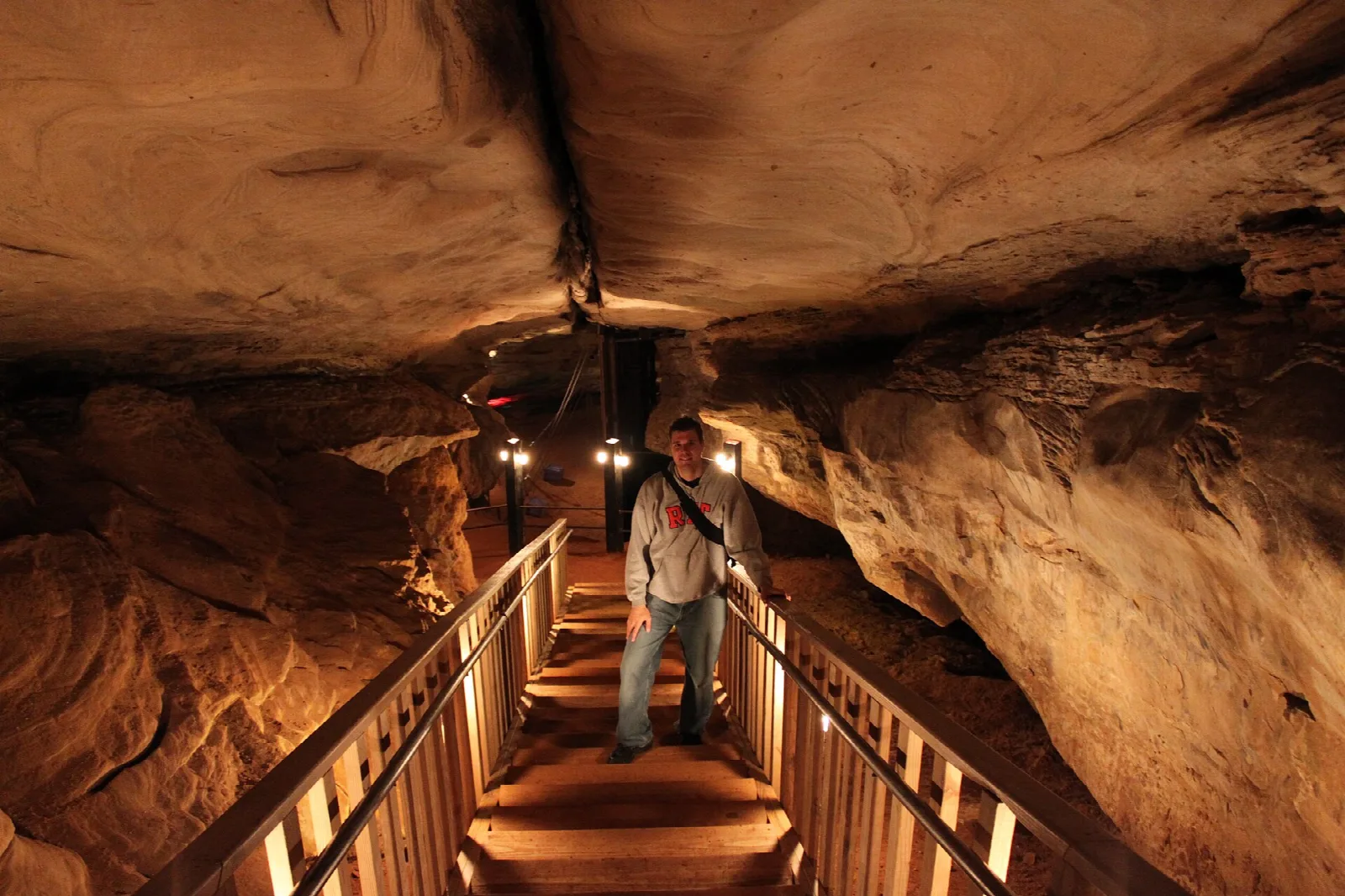Wooden stairway with railings descending in a sandstone cave