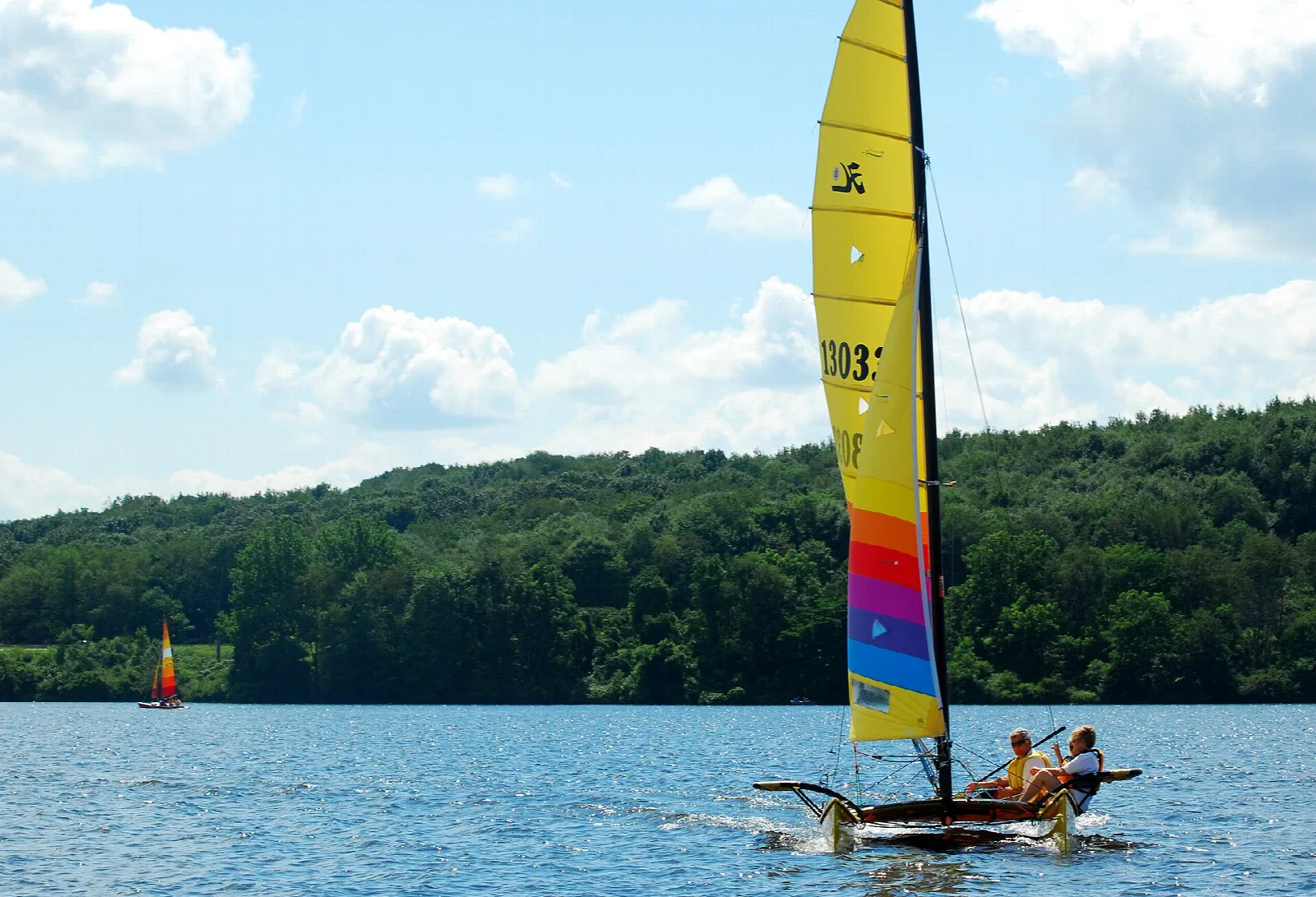 Colorful catamaran sailing on a blue lake