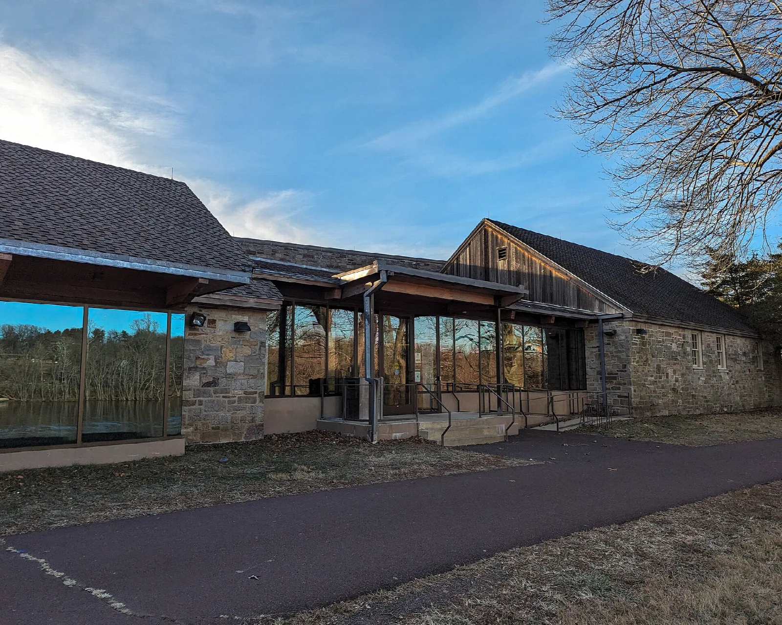 Low stone and glass visitor center beside a paved path