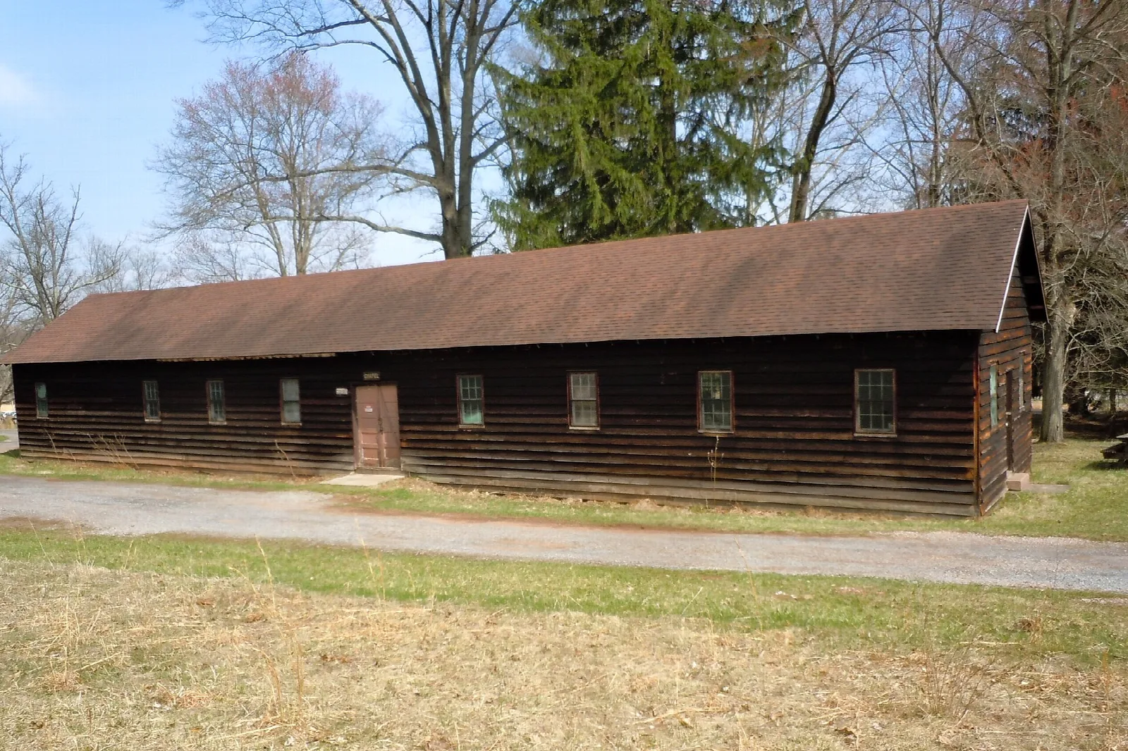 Long low log building among bare trees