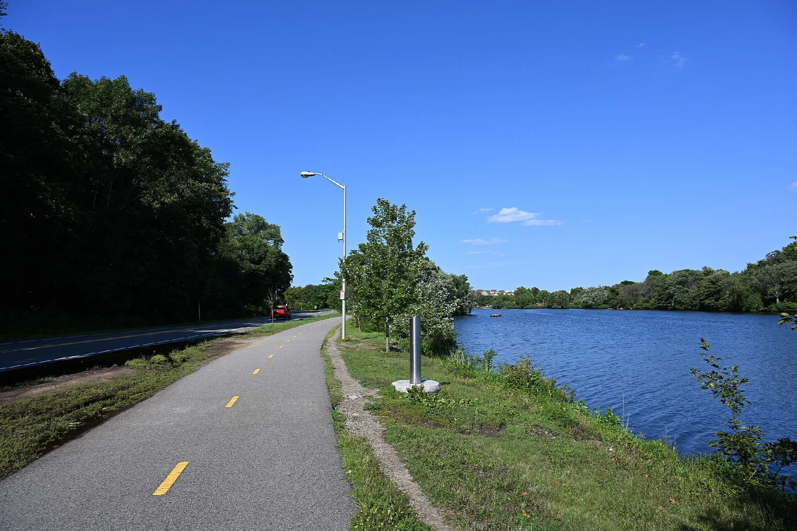 A paved bike path beside the river on a sunny day