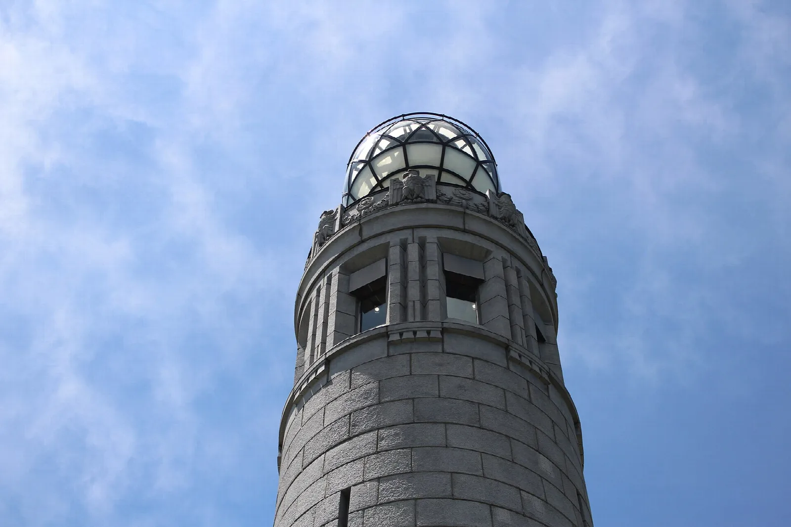 The round top of a stone tower against a blue sky