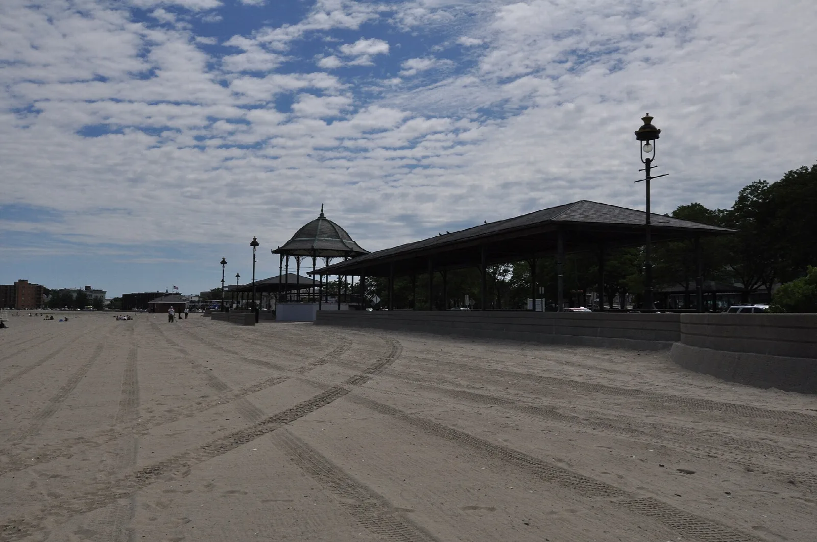 A long open-sided beachfront pavilion beside a wide sandy beach