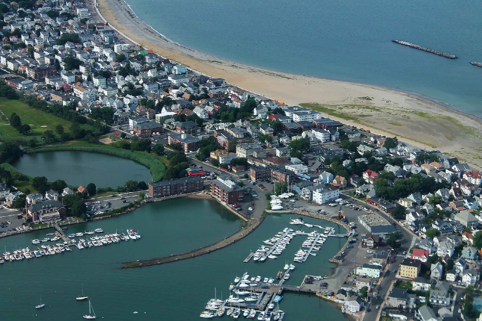 Aerial view of a long beach, a town and a marina