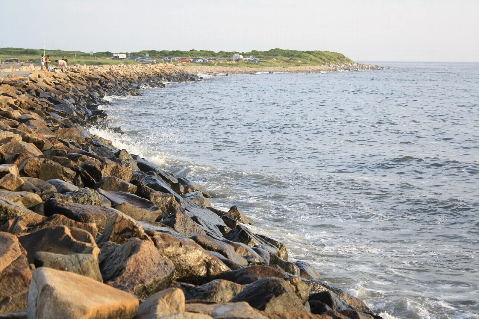 A jetty of large rocks reaching along the sea